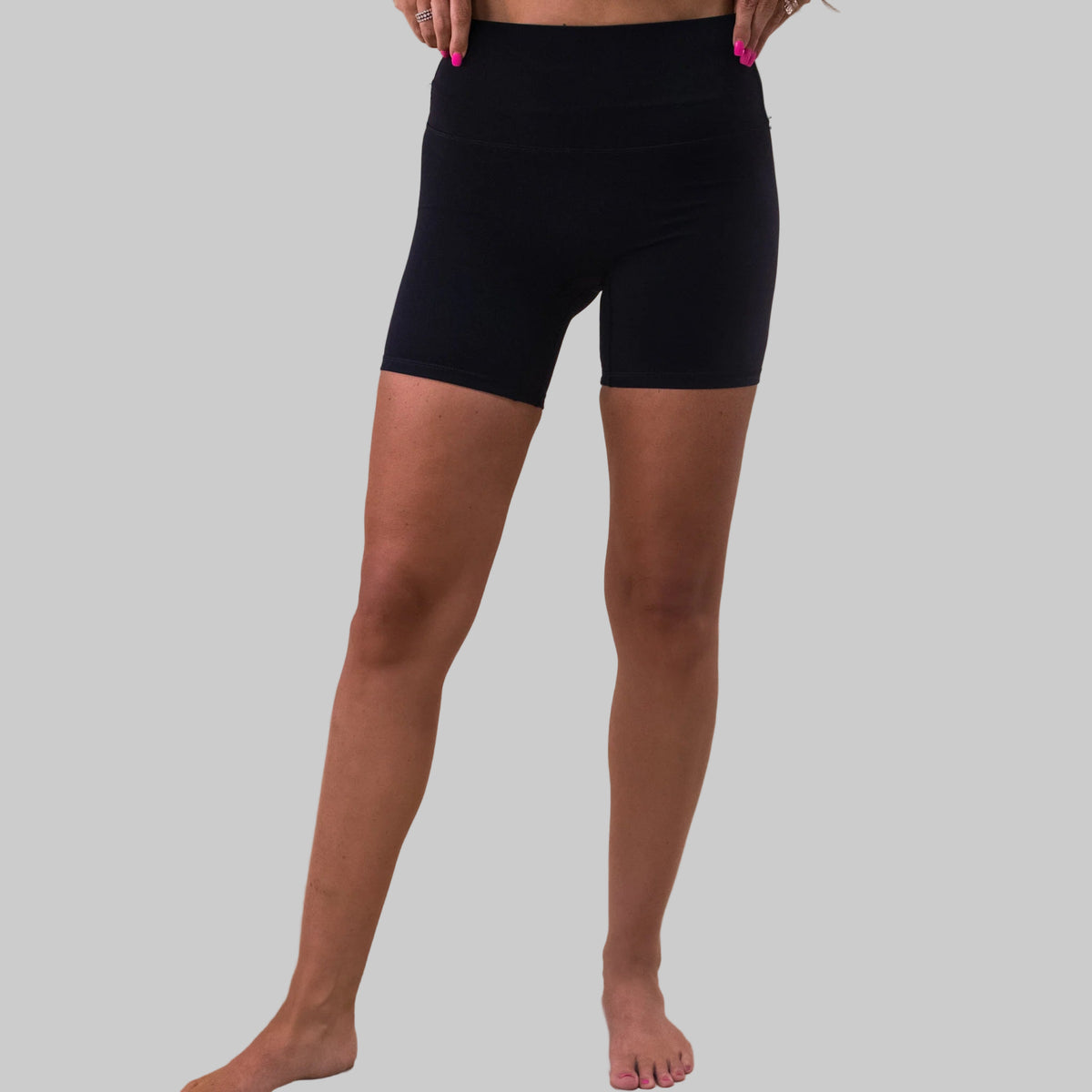 Person wearing black shorts on a beige background