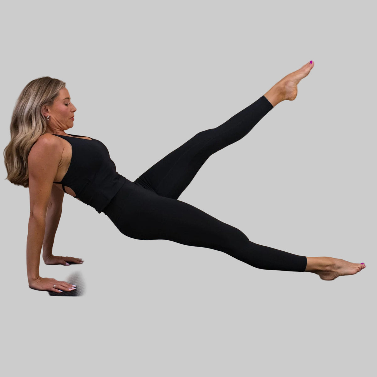 Woman performing a yoga pose on a beige background